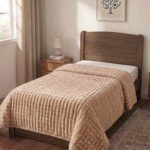 Couverture ABM 160x220 cm acrylique gaufree coloris Beige sur un lit une place