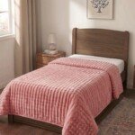 Couverture ABM 160x220 cm acrylique gaufree coloris Rose poudré sur un lit une place