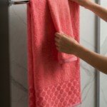 Pack de 2 serviettes de bain à pois en relief, coloris corail, 100 x 150 cm et 50 x 90 cm, 100 % coton